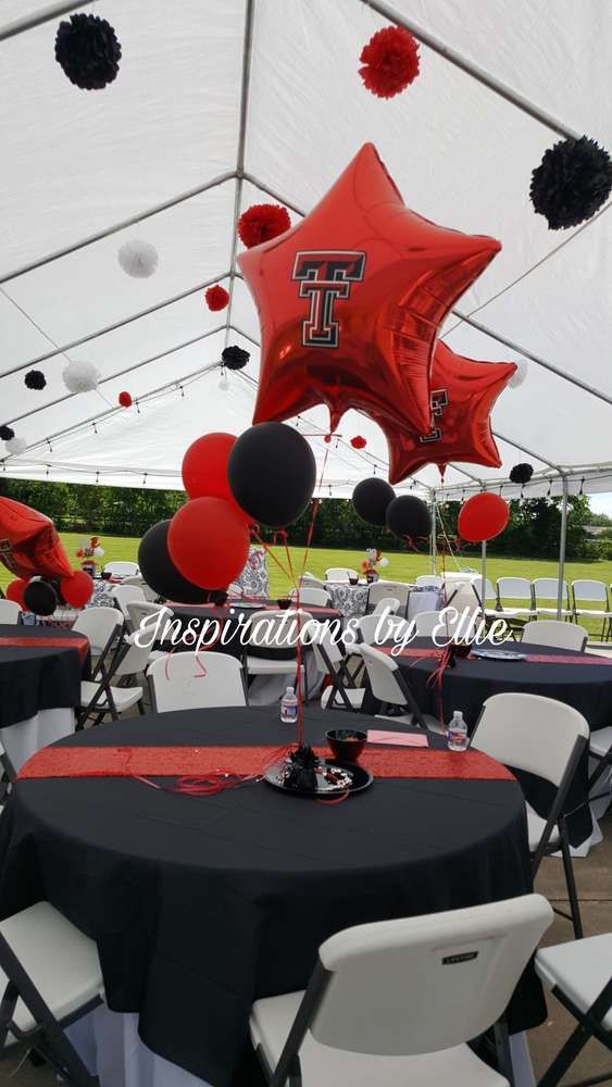 the tables are set up with black and red tablecloths, star balloons, and tissue pom poms