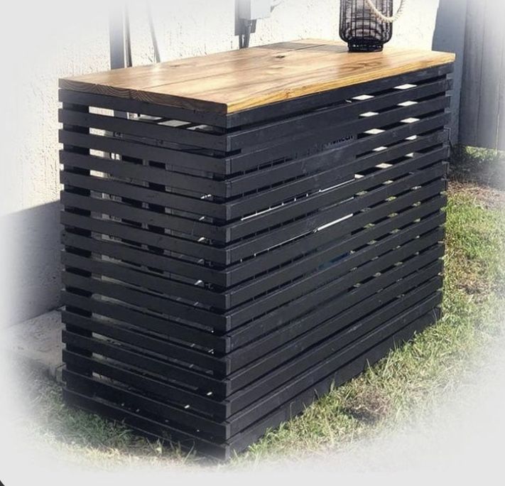 a wooden table sitting on top of a grass covered field