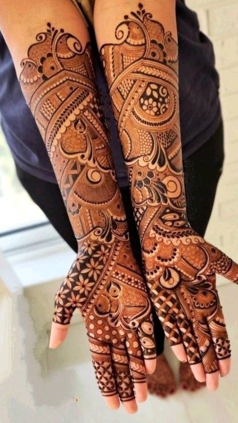 two hands with henna tattoos on them, one is showing off the intricate design