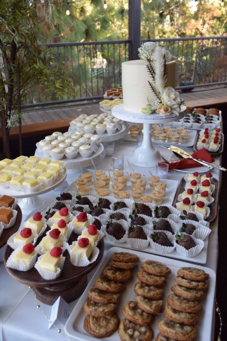 a table topped with lots of desserts and pastries