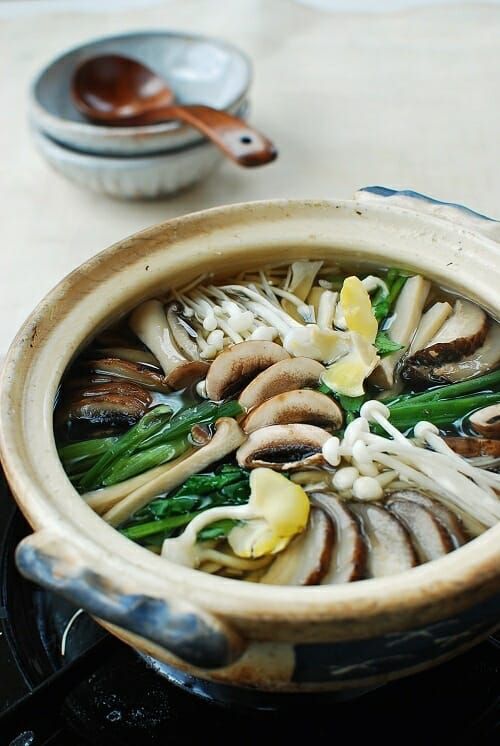 a close up of a bowl of food with mushrooms and broccoli in it