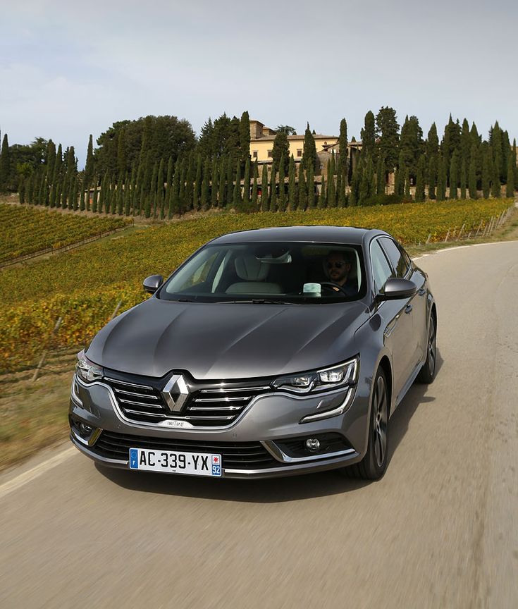 a silver car driving down a country road