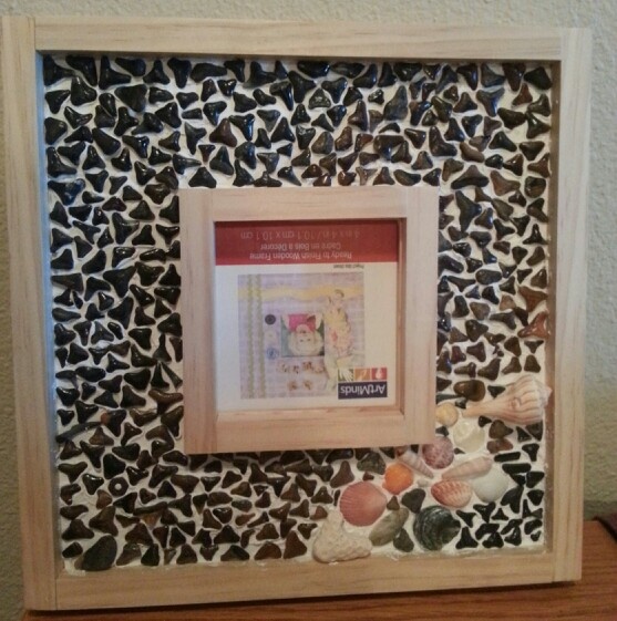 a wooden frame with shells and seashells on it