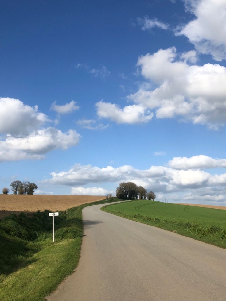 the road is empty and there are clouds in the sky