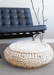 a black leather chair and white knitted ottoman