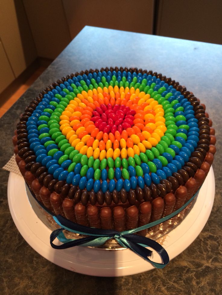 a cake decorated with multicolored icing on top of a white plate