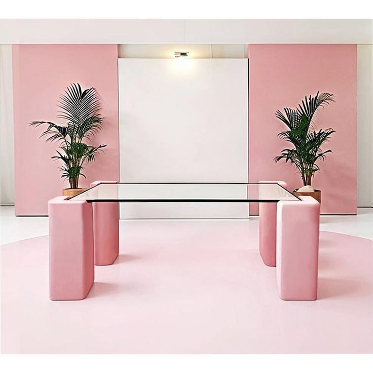 a pink room with three planters and a glass table