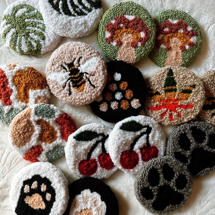 there are many crocheted buttons on the table top, all decorated in different designs