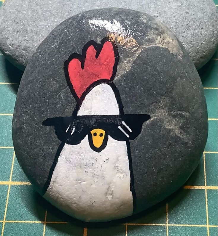 a rock painted with a chicken wearing sunglasses