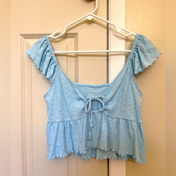 American Eagle Blue Ruffle Top Size Large Never Worn Blue Ruffle Hem Top For Beach, Blue Ruffle Tops For Summer, Trendy Blue Tops With Ruffles, Trendy Blue Ruffled Tops, Blue Ruffled Tops For Summer, Blue Short Sleeve Top With Ruffle Hem, Blue Short Sleeve Tops With Ruffle Hem, Blue Tops With Ruffle Hem And Short Sleeves, Blue Ruffled Tops For Spring