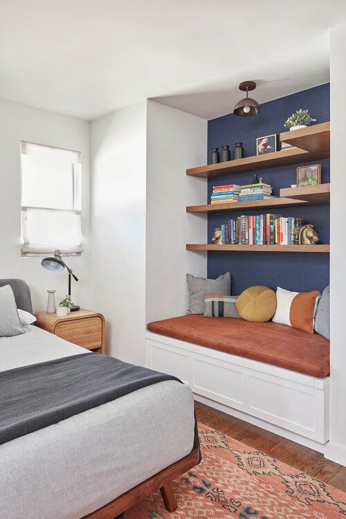 a bed room with a neatly made bed and shelves