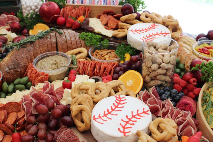 a baseball themed platter with pretzels, fruit, nuts and crackers