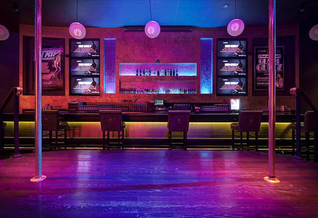 an empty bar with purple lighting in the background