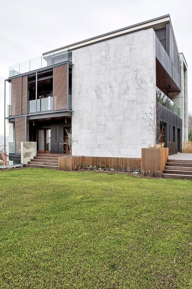 a large building sitting on top of a lush green field next to a tall wooden fence