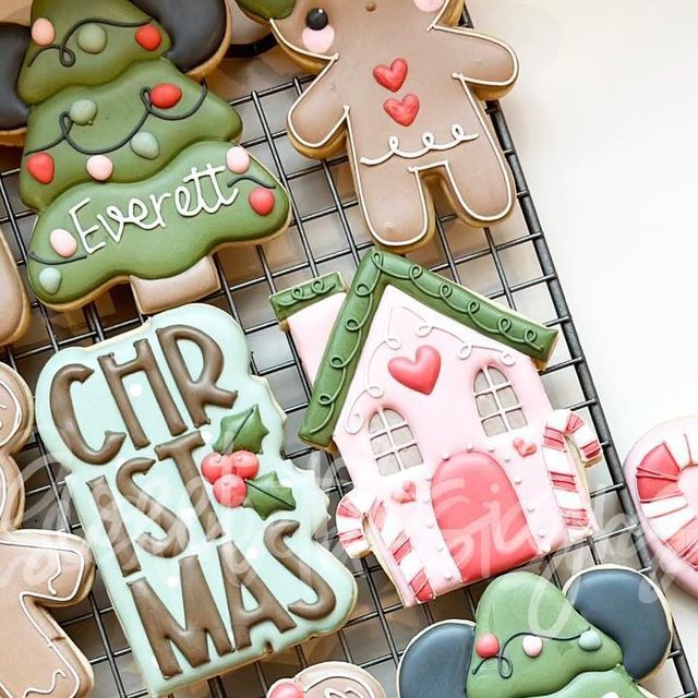 decorated cookies sitting on top of a cooling rack next to each other with the words merry christmas written on them