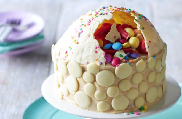 a cake with white frosting and sprinkles on it sitting on a plate