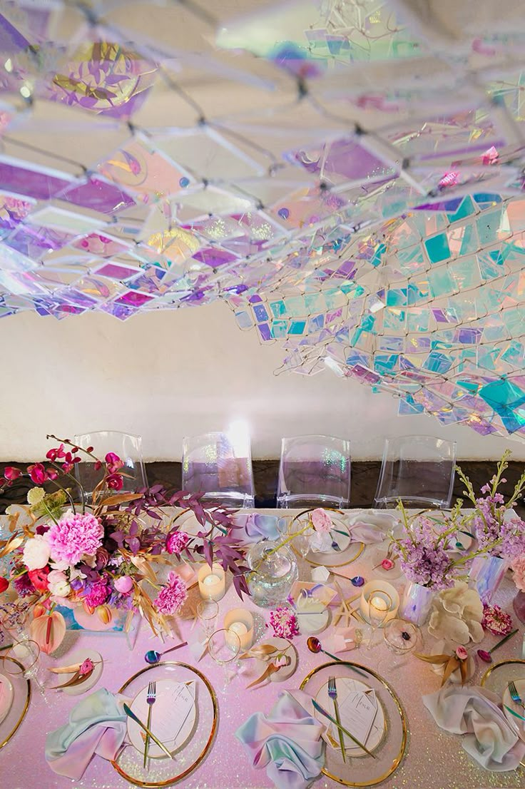 the table is covered with flowers and glass vases