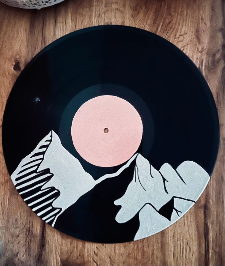 a record sitting on top of a wooden table next to a white and black object