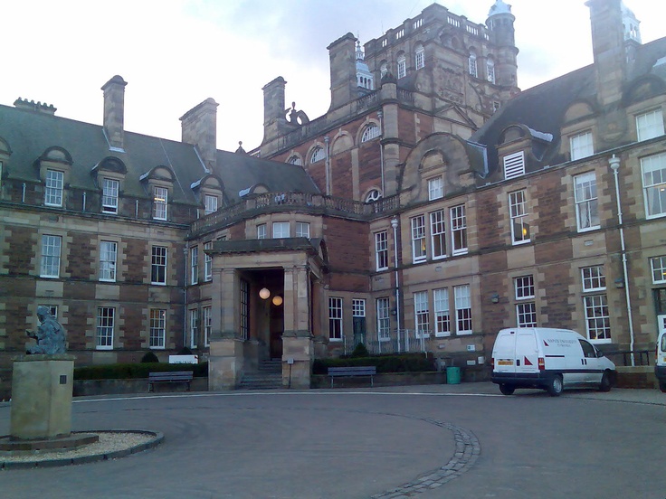 a van is parked in front of a large brick building with many windows and doors