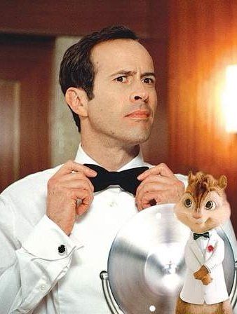 a man in a white shirt and bow tie holding a cat