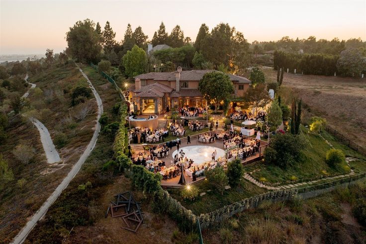 an aerial view of a house with people gathered around it at night in the evening