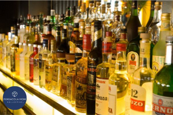 many bottles of alcohol are lined up on the bar