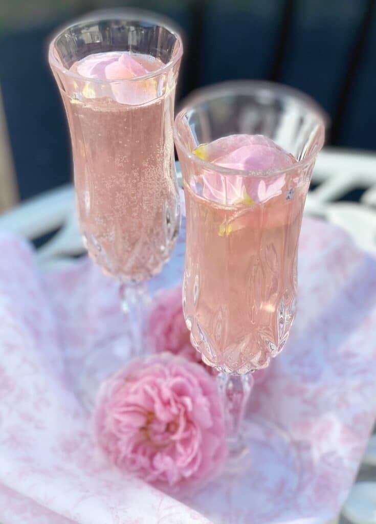 two glasses filled with pink liquid sitting next to each other on top of a table