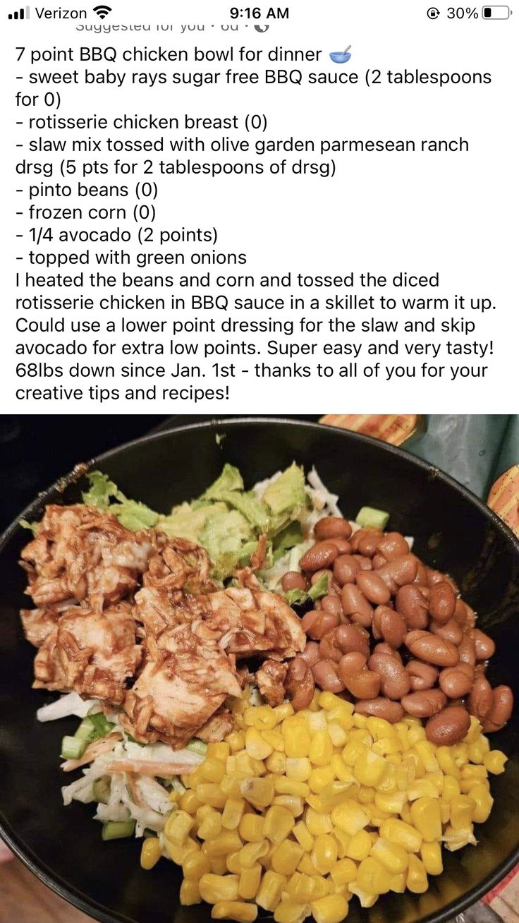 a plate filled with chicken, beans and coleslaw on top of a table