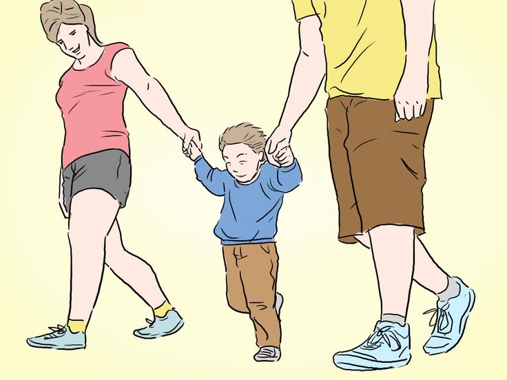 a man and woman holding hands with a small boy in front of them while walking