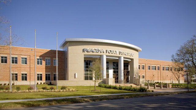 the front of a school building with grass and trees