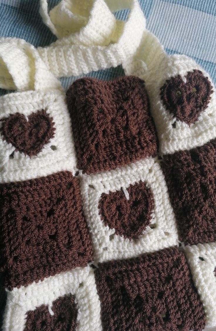 a brown and white crocheted bag sitting on top of a blue table cloth