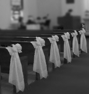 rows of pews with white sashes tied to them