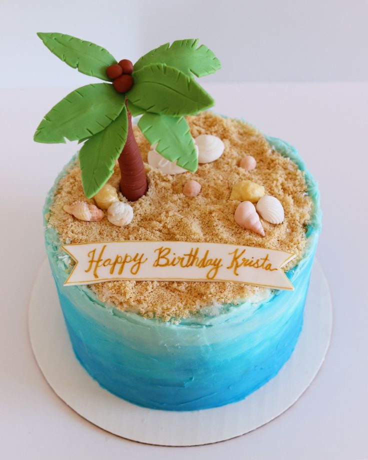 a birthday cake decorated with a palm tree and seashells