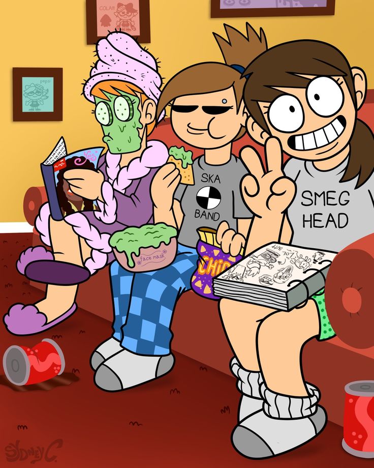 three people sitting on a couch with one holding a book and the other pointing at something