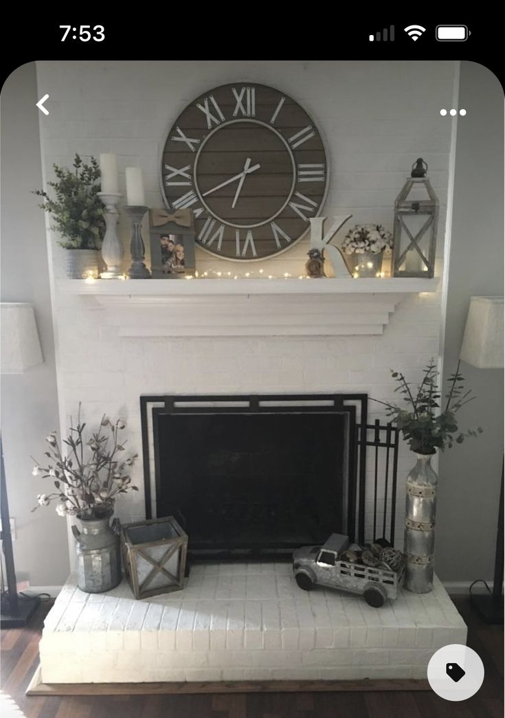 a living room with a fireplace and clock on the wall above it's mantle