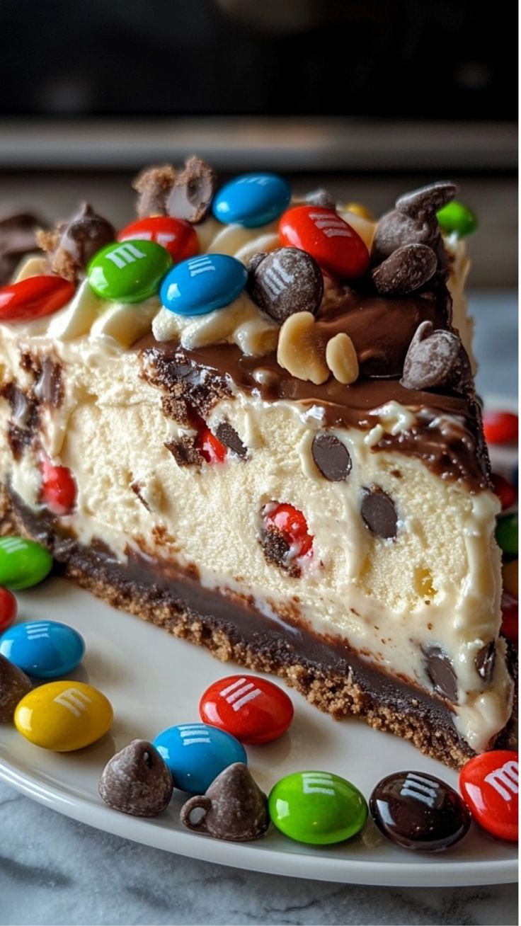 a piece of cake on a plate with candy and m & m candies around it