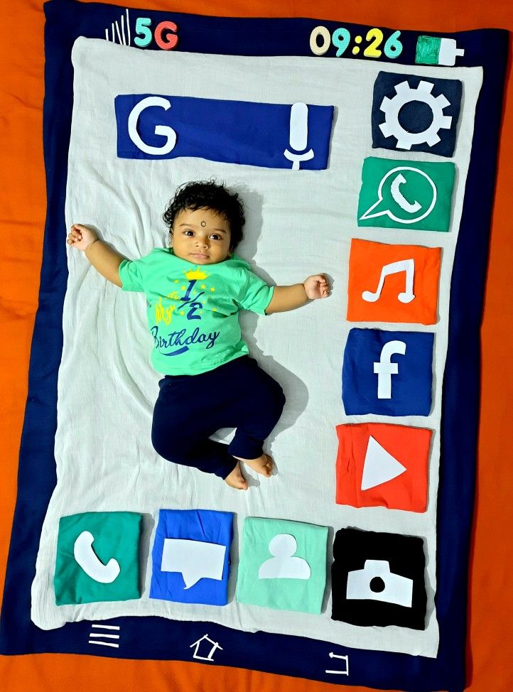 a young child laying on top of a blanket covered in appliqued letters