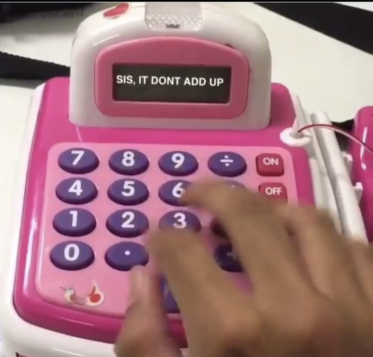 a pink and white calculator sitting on top of a table