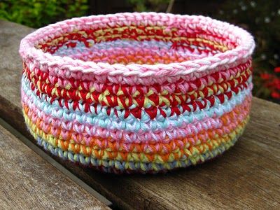 a multicolored basket sitting on top of a wooden bench