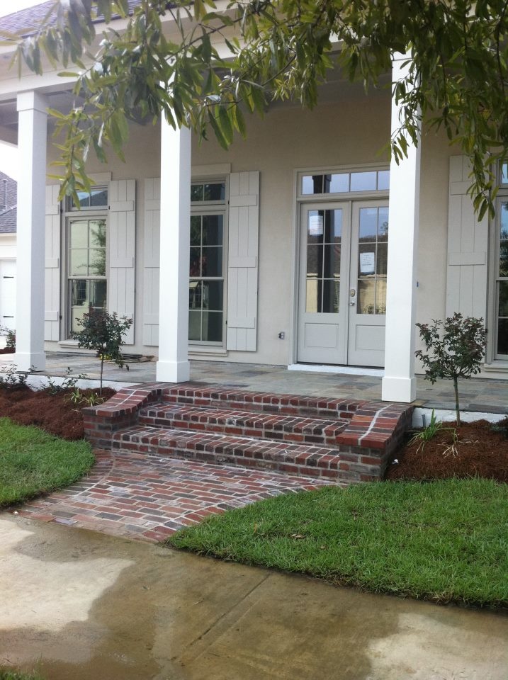 a house with white pillars and brick steps