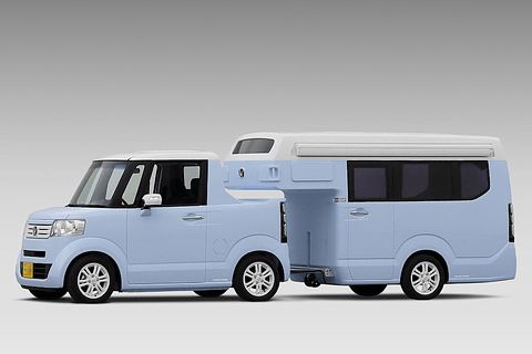 a small blue van parked in front of a gray background