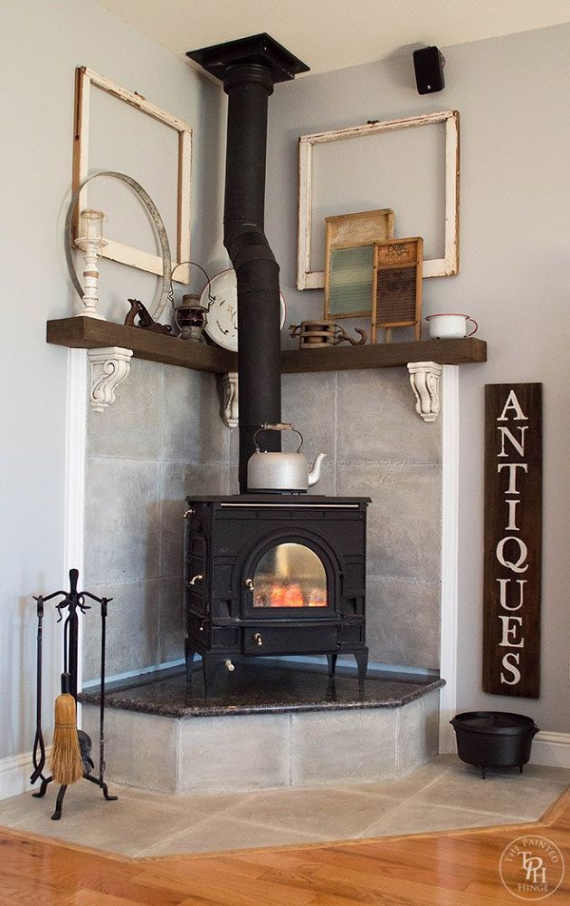 a wood burning stove sitting inside of a living room next to a wall mounted clock