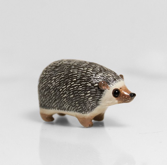 a small hedgehog figurine on a white surface