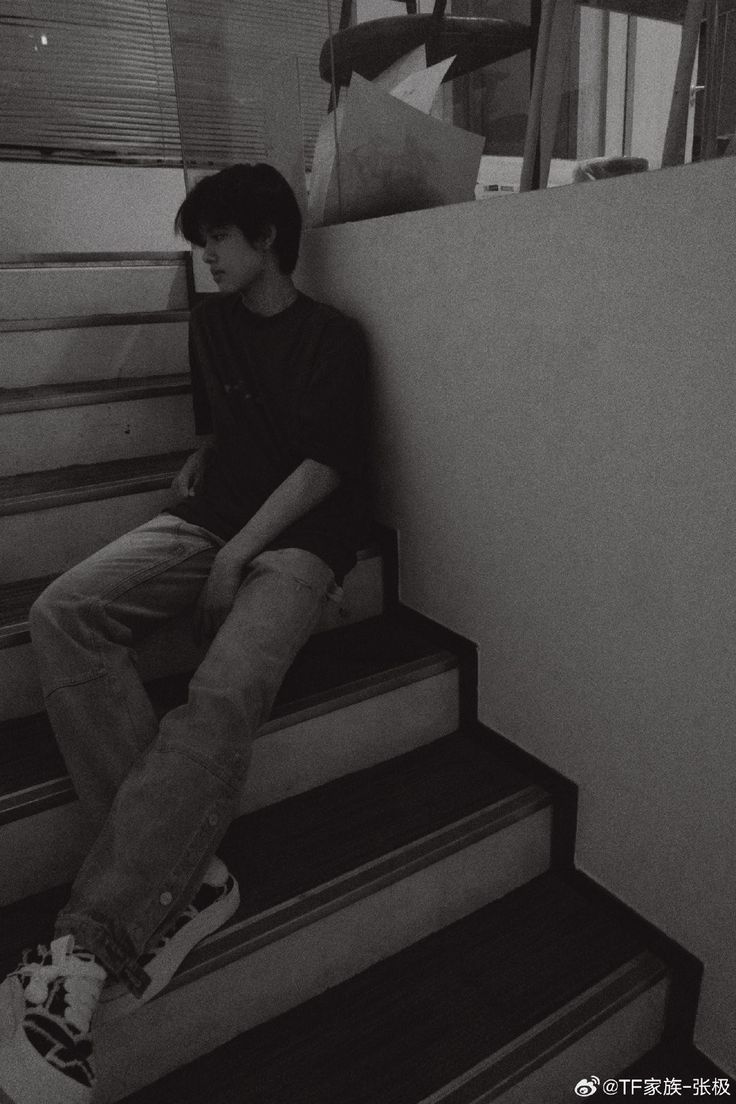 a young man sitting on top of some stairs