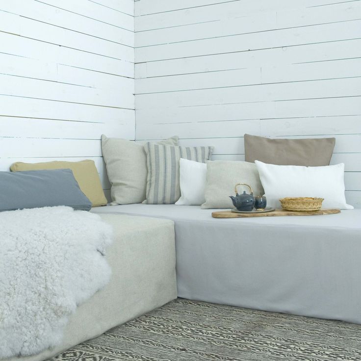 a white couch sitting on top of a rug next to a wooden table and chair