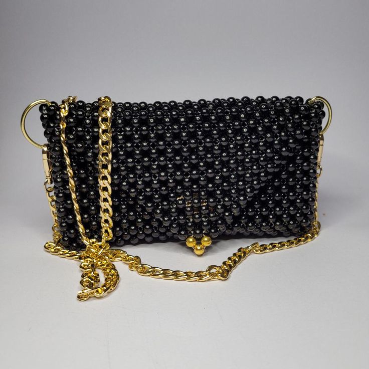 The Lena Bag is a striking accessory crafted from solid glossy beads in a distinctive circle shape. The black beads exhibit a captivating glossy finish that shines under light, making the Lena Bag a bold and elegant choice for any occasion. Luxury Black Beaded Evening Bag, Elegant Black Beaded Bags, Beaded Crossbody Shoulder Bag For Evening, Elegant Black Beaded Clutch, Elegant Rectangular Black Beaded Evening Bag, Black Shoulder Bag With Chain Strap For Events, Elegant Black Beaded Rectangular Evening Bag, Elegant Party Bag With Black Beads, Elegant Party Bags With Black Beads