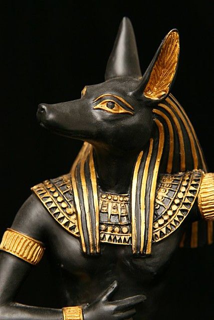 an egyptian figurine is shown in black and gold