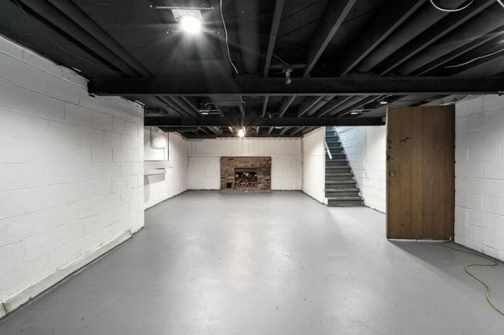 an empty room with white walls and stairs