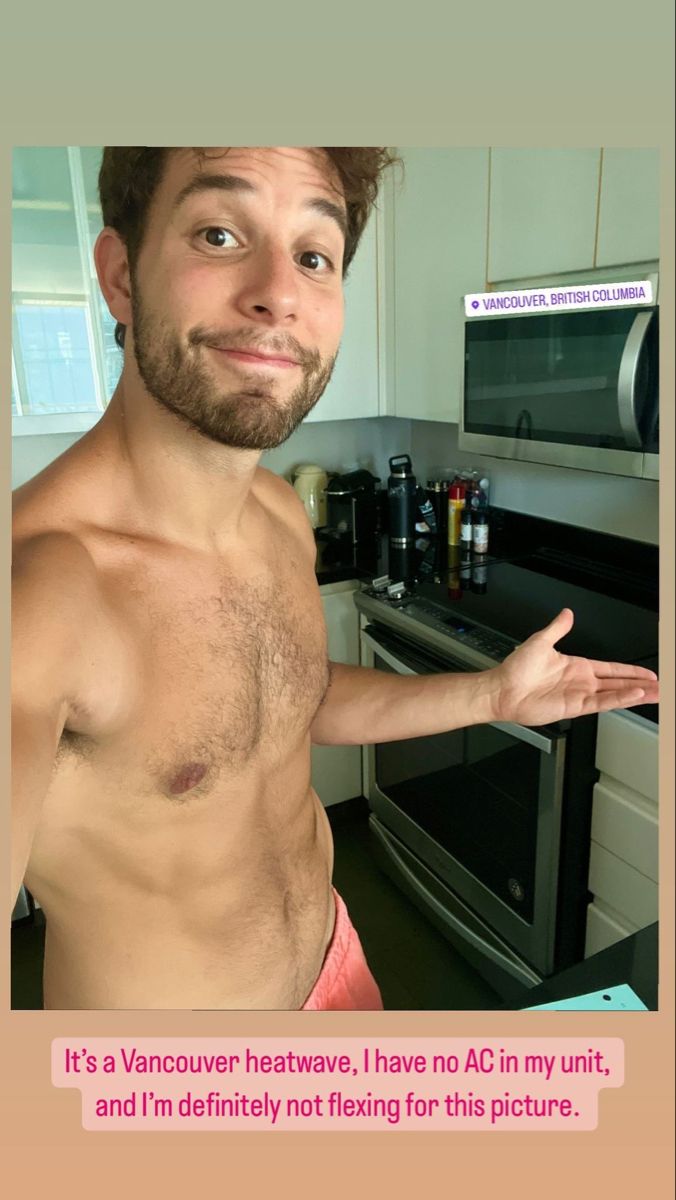 a man with no shirt standing in front of an oven and holding his hand out