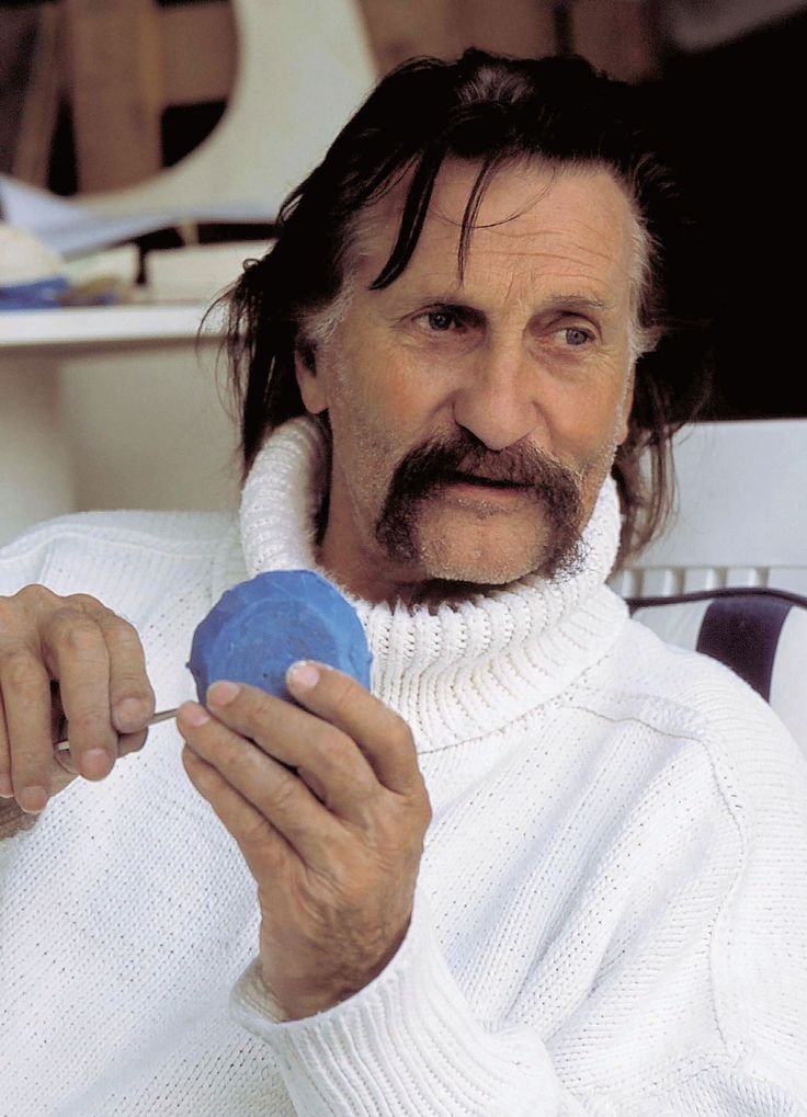 a man in white sweater holding a blue object